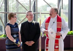 LCMS President Rev. Dr. Matthew C. Harrison, right, welcomes new Chief Mission Officer Rev. Kevin D. Robson and his wife, Peg, following Robson's May 18 installation service in St. Louis. (LCMS/Frank Kohn)