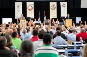 Delegates to the LCMS Michigan District convention respond to a question with a show of hands. At the podiums are, from left, district President Rev. Dr. David P.E. Maier and First Vice-President Rev. Mark Brandt. The convention was June 28-30 at Concordia University, Ann Arbor, Mich. (Elisa Schulz)