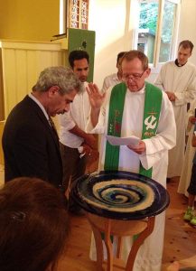 Rev. Hugo Gevers prays for Eizadi Shahriyar during a Farsi and German Baptismal Rite, July 27, 2014, at St. Trinitatisgemeinde in Leipzig, Germany. Shahriyar continues to be an active member of the congregation. Gevers is a missionary to migrants and the underserved in Volkmarsdorf in Leipzig for the Selbständige Evangelisch-Lutherische Kirche (SELK), an LCMS partner church. (Coiurtesy of St. Trinitatisgemeinde)