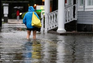 A woman walks down a flooded sidewalk toward an open convenience store in Charleston, S.C., Oct. 4. The Rev. Michael Meyer, disaster-response manager for the LCMS Office of National Mission, has deployed to assist the LCMS Southeastern District in essential damage assessments as flooding continues in South Carolina. (AP Photo/Chuck Burton)