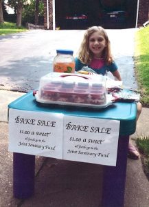 Abby Sommer, whose father is a student at Concordia Seminary, St. Louis, sells cupcakes outside her home in May. She raised $36 for the LCMS Joint Seminary Fund, and mailed it to the fund along with a note that said, in part, "We hope you and others are mightily blessed by this." (Courtesy of Sommer family)