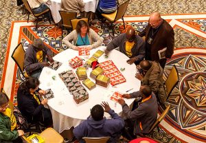 In a two-hour Nov. 20 servant event, participants at the 2015 Lutheran Church Extension Fund Fall Leadership Conference in Atlanta, assemble items including Bibles and messages of hope to fill 500 backpacks for homeless people served by the city’s Stepping Stone Mission, an LCMS Recognized Service Organization. (Lutheran Church Extension Fund)