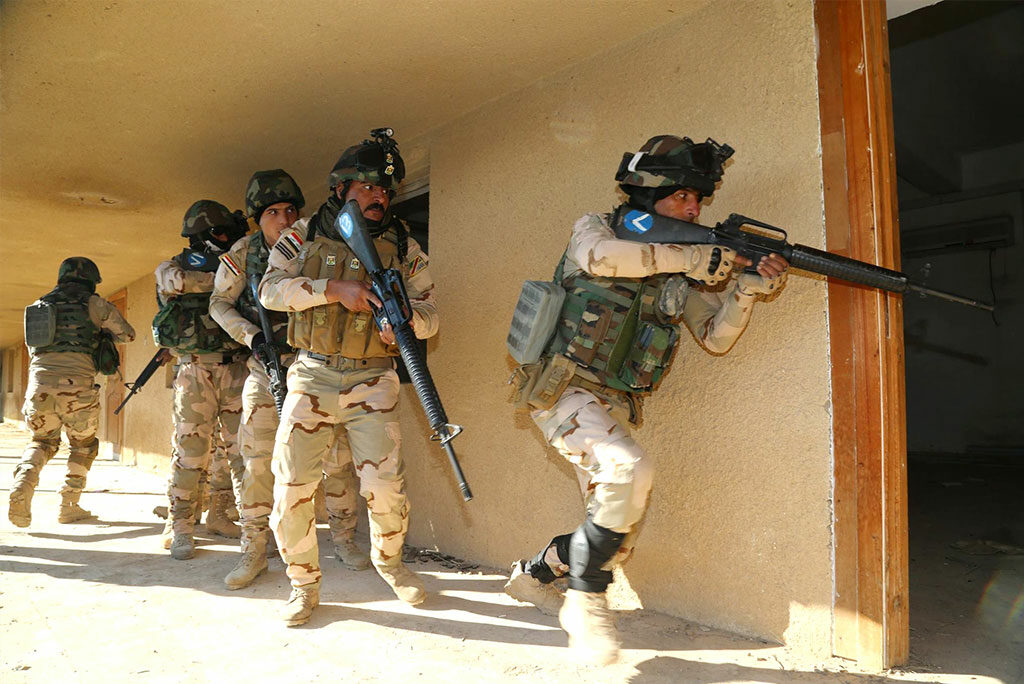 Iraqi soldiers enter a room after breaching the doorway to ensure that it is clear at Camp Taji training Jan. 10 in Iraq. The training is part of a multinational effort to train Iraqi security forces to defeat the Islamic State of Iraq and the Levant. (Army photo by Sgt. Kalie Jones)