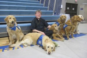 The Rev. Robert C. Trueblood, pastor of St. James Evangelical Lutheran Church in Northrop, Minn., poses with six of the 10 "comfort dogs" from Lutheran Church Charities that visited the town after fire destroyed the church building. (Elaine Tessler/Immanuel Lutheran Church, Belvidere, Ill.)