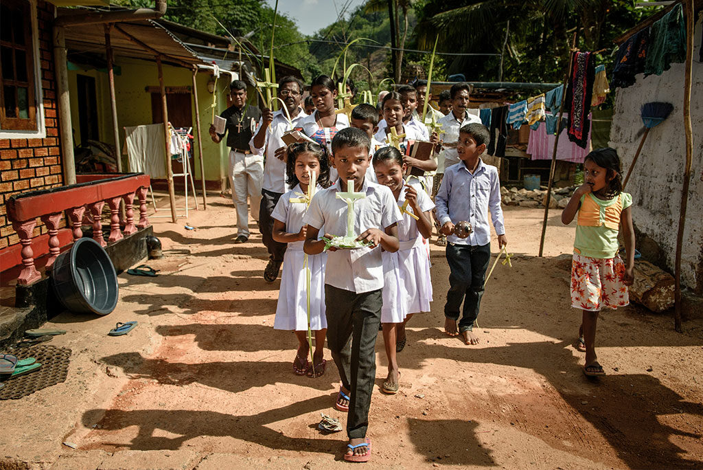 Worshipers from Immanuel Lutheran Church at the Eila Rubber Plantation process through their village singing Palm Sunday hymns.