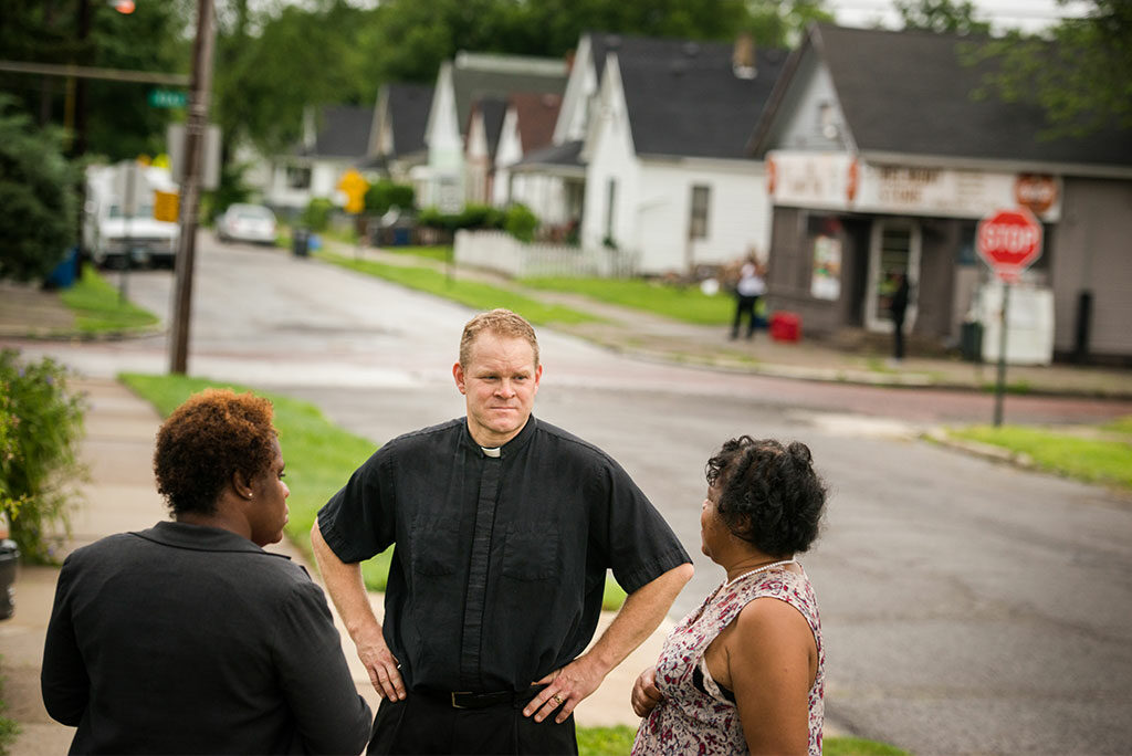 While conducting a survey last summer for a new church location in Toledo, Ohio, the Rev. Peter M. Burfeind talks with community advocate Alicia Smith (left) and a resident. Burfeind is an LCMS national missionary to that city and campus pastor at the University of Toledo. (LCMS/Erik M. Lunsford)