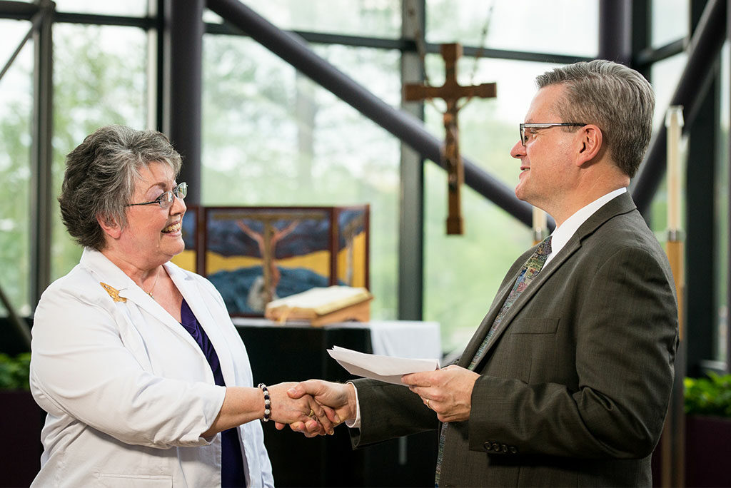 Sally Handrick, chairman of the Lutheran Women’s Missionary League’s Mission Grants Committee, presents LCMS Chief Mission Officer Rev. Kevin Robson with a check for an LWML grant to LCMS Disaster Response. The grant will help more than 20 LCMS congregations purchase and outfit disaster-response trailers. (LCMS/Erik M. Lunsford)