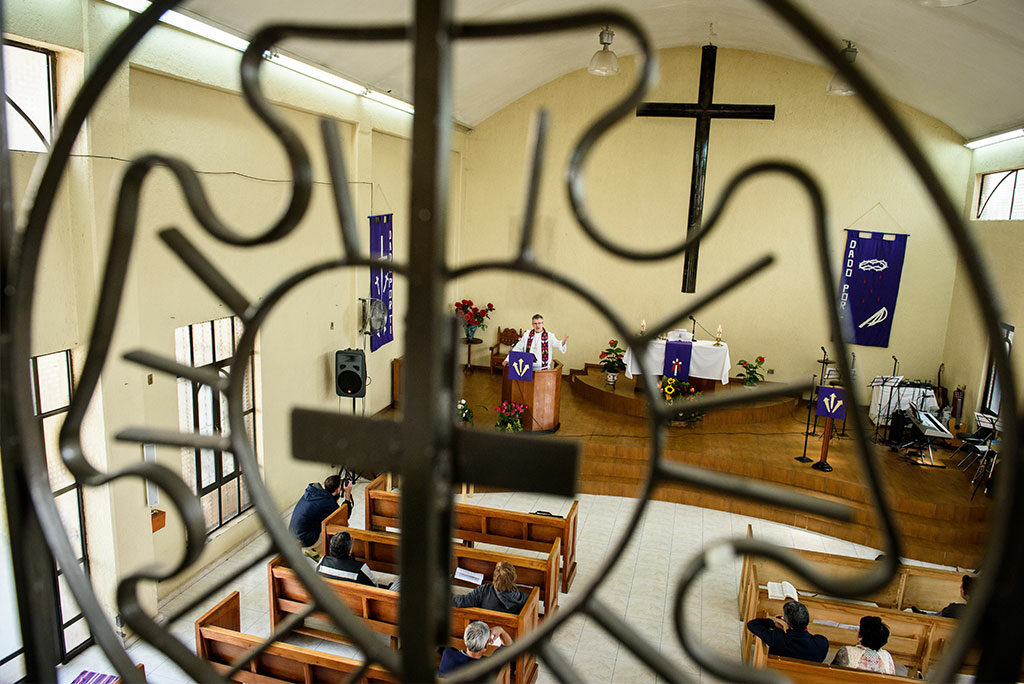 Framed by Martin Luther's seal, LCMS Career Missionary Rev. Daniel Conrad delivers a sermon at St. Peter Lutheran Church in Mexico City, where he is interim pastor as he helps the Lutheran Synod of Mexico clarify and develop a route to ordination for future pastors.