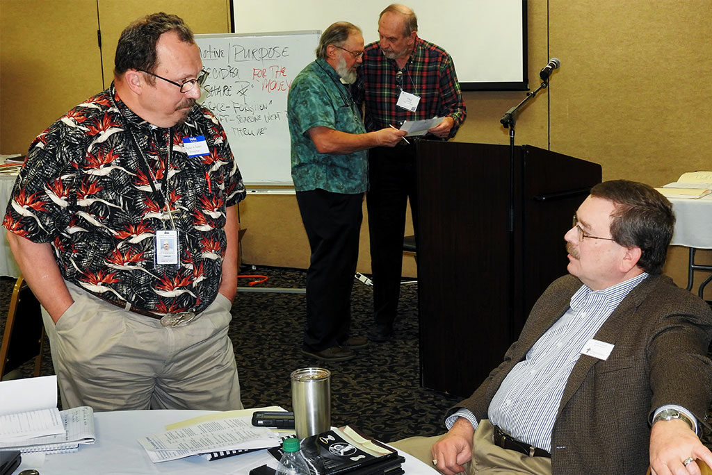 LCMS First Vice-President Rev. Dr. Herbert C. Mueller Jr. (bottom right) discusses prison ministry with the Rev. G. Robert Heimgartner, a prison chaplain in Centralia, Ill., as do the Rev. E. James Rivett (top left), Southern Illinois District senior prison ministry coordinator, and Chaplain Paul Emmel, a Minnesota South District prison-ministry representative, during a break at the LCMS Prison Ministry Conference. (LCMS/Roger Drinnon)