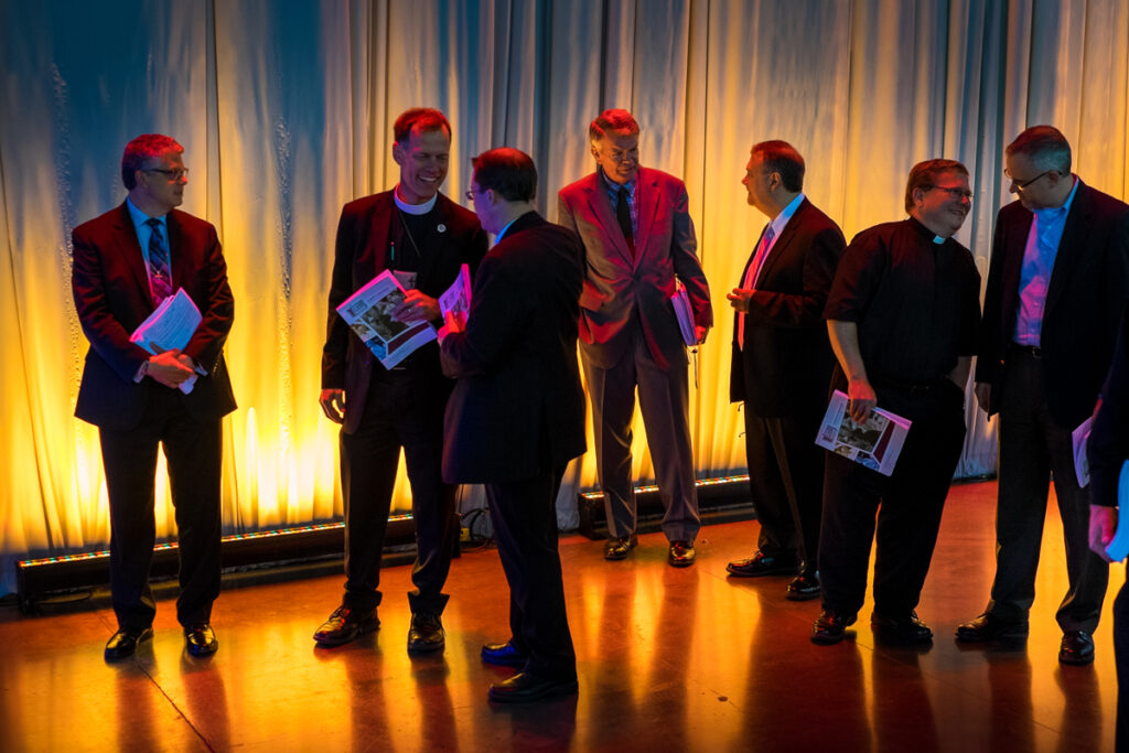 Members of Committee 6 for Seminaries and the two LCMS seminary presidents prepare to address the 66th Regular Convention of The Lutheran Church—Missouri Synod on Wednesday, July 13, 2016, in Milwaukee. The Rev. Dr. Dale A. Meyer, president, Concordia Seminary, St. Louis, pictured fourth from the left, talks with the Rev. Dr. Larry R. Rast, president, Concordia Theological Seminary, Fort Wayne, Ind. (LCMS/Michael Schuermann)