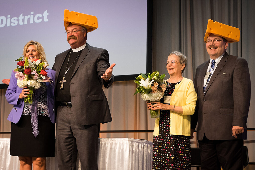 The Rev. Dr. Matthew C. Harrison, president of the LCMS; his spouse, Kathy Harrison; the Rev. Herb Mueller, the re-elected LCMS first vice-president; and his spouse, Faith Mueller, react after receiving foam cheeseheads on Sunday, July 9, 2016, in Milwaukee during the 66th Regular Convention of The Lutheran Church–Missouri Synod. (LCMS/Michael Schuermann)