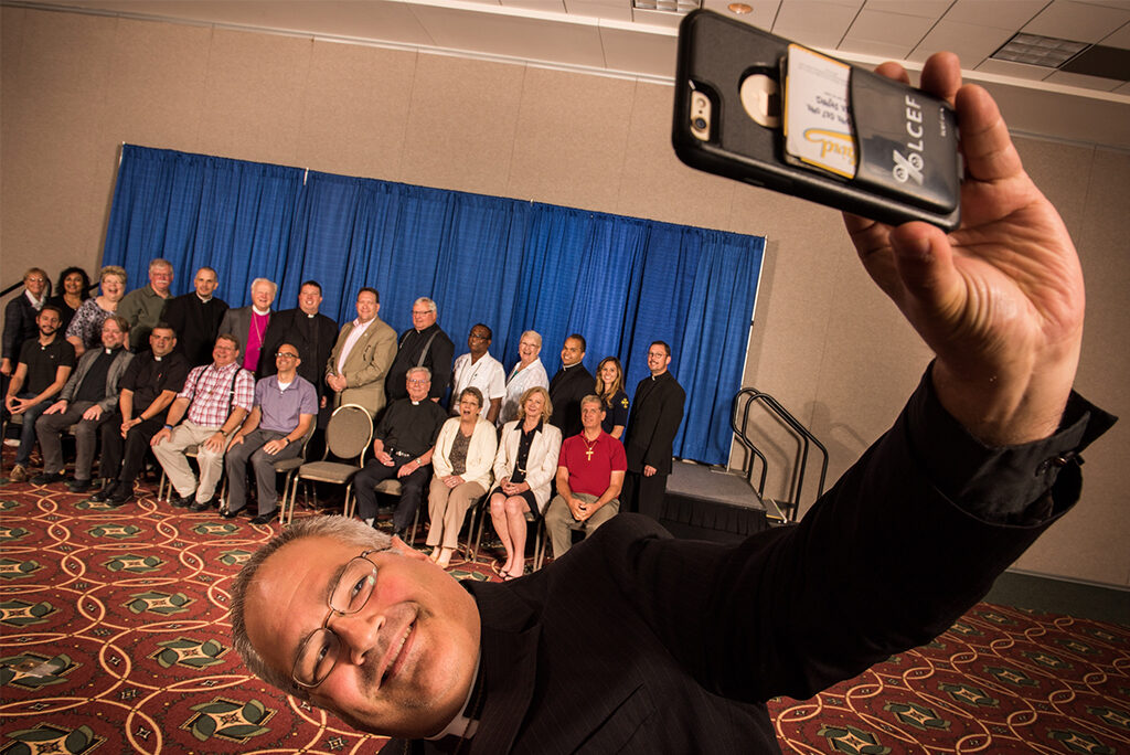 The Rev. Derek G. Lecakes, president of the LCMS Atlantic District, takes a "selfie" during a group photograph on Wednesday, July 13, 2016, at the 66th Regular Convention of The Lutheran Church—Missouri Synod in Milwaukee. (LCMS/Michael Schuermann)