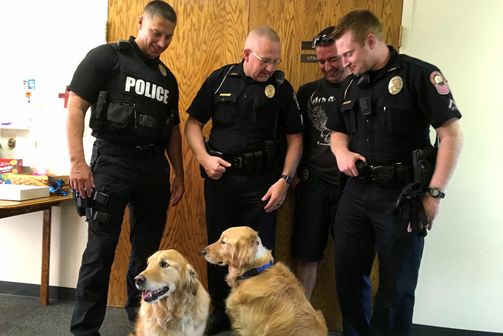 Joplin, Mo., police officers who responded to the Aug. 13 shooting there visit Immanuel Lutheran Church to receive the thanks of members involved in the congregation’s comfort dog ministry and to check on the recovery of the two dogs wounded in the shooting. (Immanuel Lutheran Church)