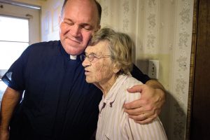 The Rev. David Buss, senior pastor of Trinity Lutheran Church, Baton Rouge, La., visits church charter member Althea Neptune in her flood-damaged home Sept. 14. (LCMS/Erik M. Lunsford)