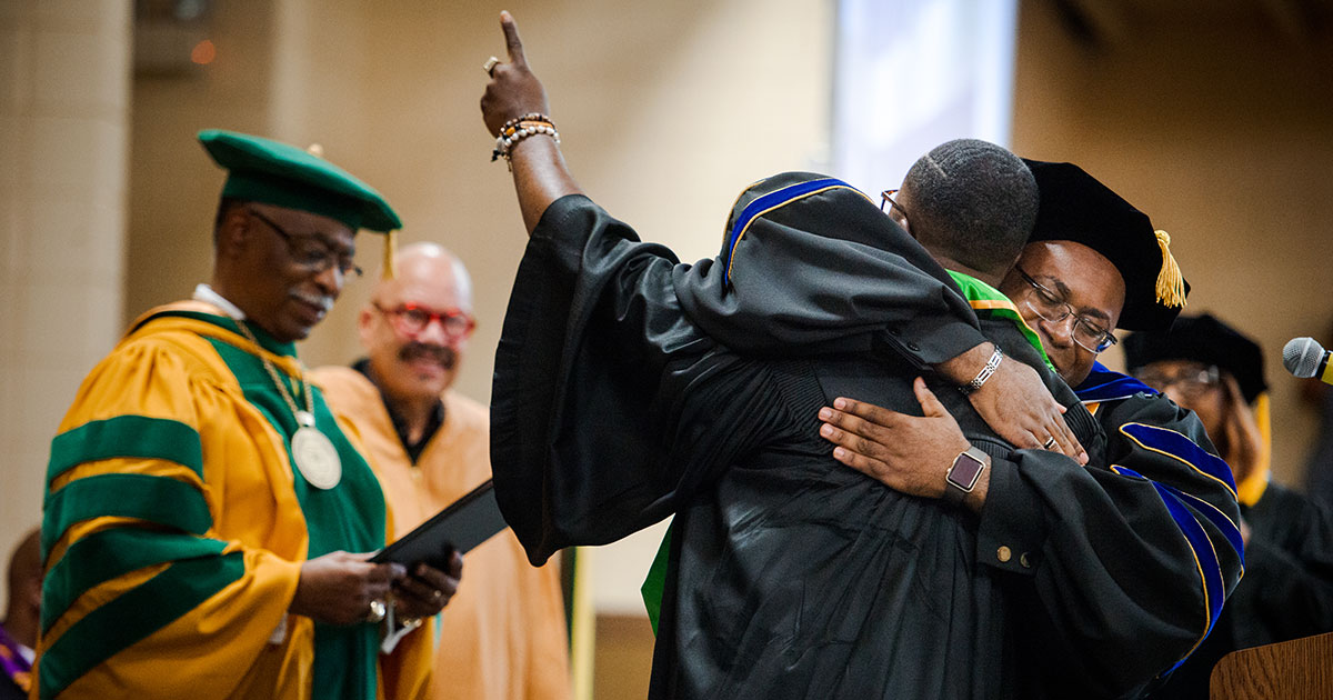 Dr. Glenn King Jr., dean of Business and Computer Information Systems at Concordia College Alabama, hugs a graduate during the commencement ceremony on Saturday, April 28, in Selma, Ala. (LCMS/Erik M. Lunsford)