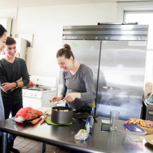 LCMS national missionary Rebecca Wagner (center) prepares lunch at the Luther House, which is near the University of Minnesota in Minneapolis, on Feb. 21, 2018. She is joined by (from left) Fiona, an international student, Andrew Kind, and Bekah Zimmerman, a student studying Japanese. (LCMS/Erik M. Lunsford)