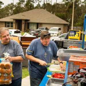 The Rev. Paul McComack (center), pastor of Trinity Lutheran Church, Panama City, Fla., and the Rev. Wayne Watts, associate pastor, prepare food for neighbors from Trinity’s outreach kitchen setup in a flooded neighborhood of Pensacola, Fla., on Tuesday, Sept. 22, 2020, in the aftermath of Hurricane Sally. LCMS Communications/Erik M. Lunsford