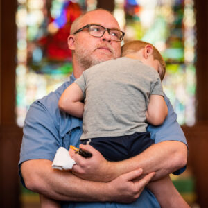The Rev. Randy Blankschaen, pastor of Immanuel Lutheran Church, Pensacola, Fla., holds his sleeping son as he assesses damage to the sanctuary in the aftermath of Hurricane Sally on Tuesday, Sept. 22, 2020. LCMS Communications/Erik M. Lunsford