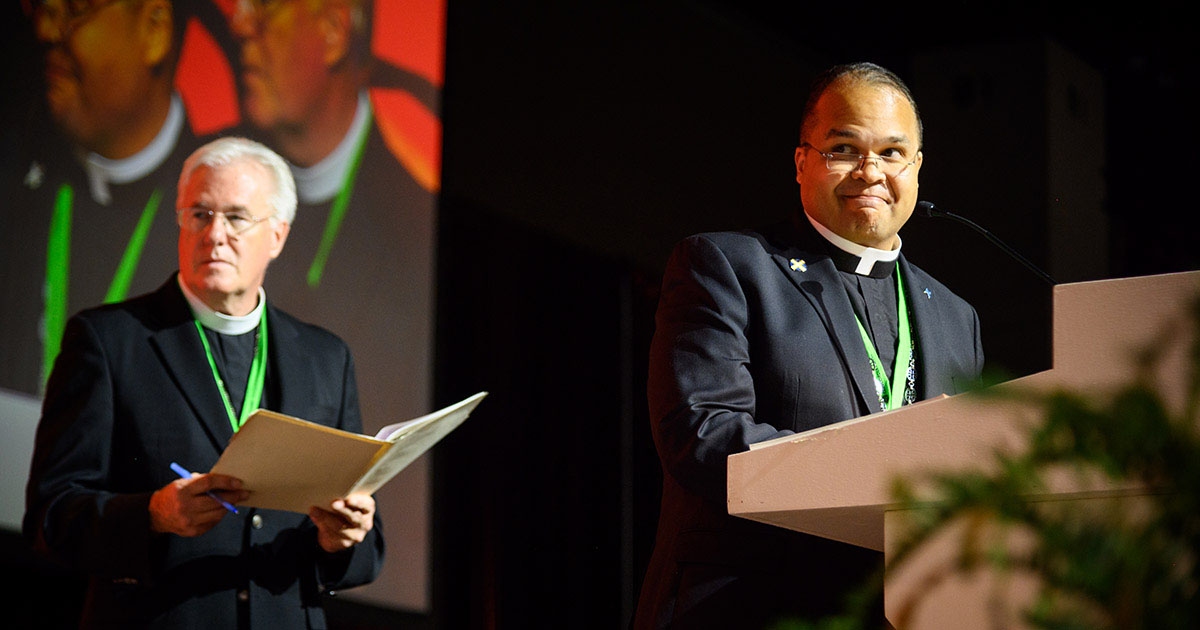 Oklahoma District President Rev. David R. Nehrenz, chairman of Floor Committee 1 (left), and Atlantic District President Rev. Dien A. Taylor, an advisory ordained member of Floor Committee 1 (right), present Res. 1-02A to the floor during the committee’s July 31 presentation to the 68th Regular Convention of the LCMS in Milwaukee. (LCMS/Frank Kohn)
