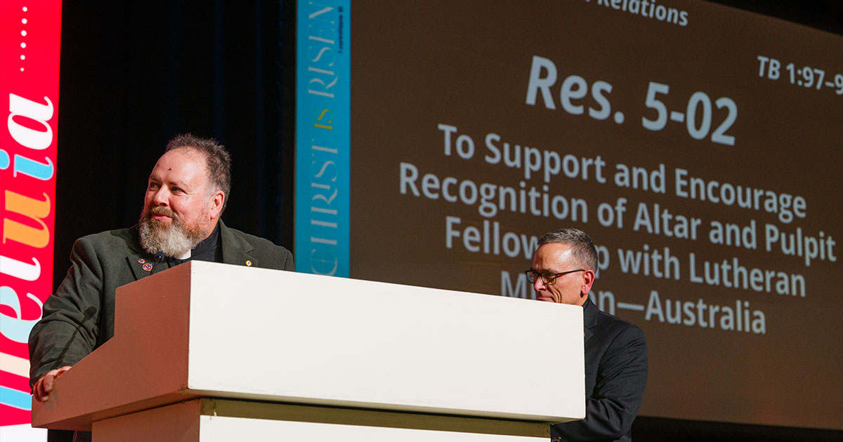 The Rev. Matthew Anker, president of Lutheran Mission–Australia, addresses The Lutheran Church—Missouri Synod convention following the passage of Res. 5-02 on July 21 while the Rev. Dr. Jonathan Shaw, director of LCMS Church Relations, looks on. (LCMS/Erik M. Lunsford)